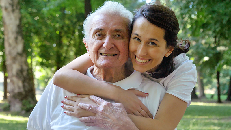 Smiling nurse hugging patient