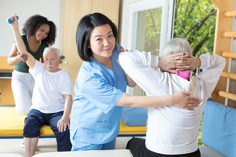 Nurse helping elderly patient exercise